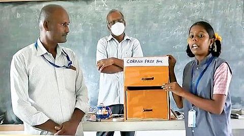 ரூபாய் நோட்டுகளில் படர்ந்துள்ள கிருமி தொற்றுகளை எளிதாக அழிக்கும் புற ஊதா கதிர் பெட்டகத்தை வடிவமைத்துள்ள மாணவி சத்யா. அருகில், அறிவியல் ஆசிரியர் தமிழ்கனி உள்ளிட்டோர்.
