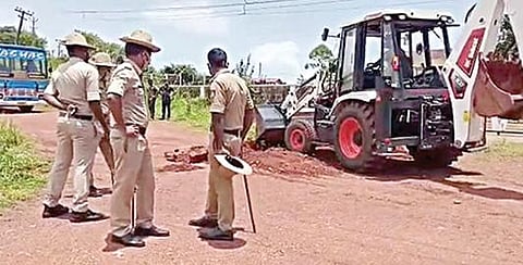 கேரள மாநிலத்தவர்கள் கர்நாடகாவுக்குள் நுழைவதை தடுப்பதற்காக எல்லைப் பகுதியில் ஜேசிபி மூலம் குழி தோண்டும் கர்நாடக போலீஸார்.