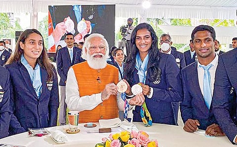 டோக்கியோ ஒலிம்பிக்கில் கலந்து கொண்ட இந்திய விளையாட்டு வீரர், வீராங்கனைகளுக்கு பிரதமர் நரேந்திர மோடி டெல்லியில் உள்ள தனது இல்லத்தில் நேற்று காலையில் விருந்தளித்தார். இந்நிகழ்ச்சியில், பி.வி.சிந்து பாட்மிண்டனில் வென்ற பதக்கங்களை பிரதமர் மோடியிடம் காட்டினார். படம்: பிடிஐ