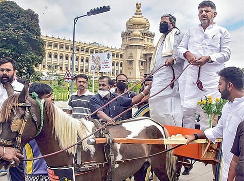 பெட்ரோல், டீசல் விலை உயர்வைக் கண்டிக்கும் விதமாக கர்நாடகா சட்டப்பேரவைக் கூட்டத்தொடரில் கலந்து கொள்ள நேற்று குதிரை வண்டியில் சென்ற அம்மாநில சட்டப்பேரவை எதிர்க்கட்சித் தலைவர் சித்தராமையா மற்றும் மாநில காங்கிரஸ் தலைவர் டி.கே. சிவக்குமார். படம்: பிடிஐ