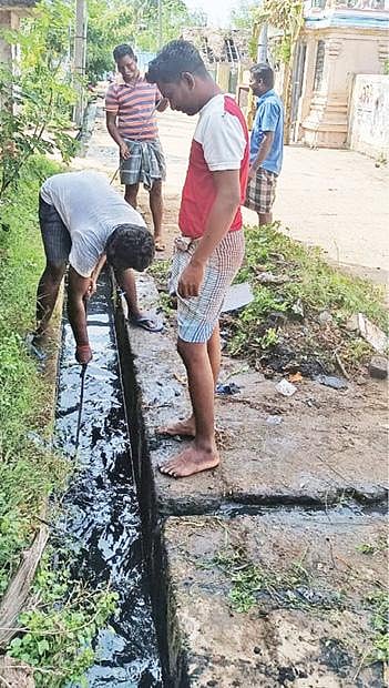 கிருமாம்பாக்கம் பகுதியில் கழிவுநீர் வாய்க்காலை சுத்தம் செய்யும் இளைஞர்கள்.