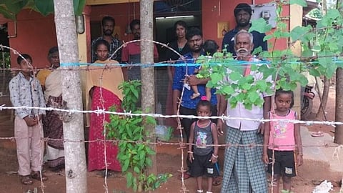 கம்பி வேலிக்கிடையே நிற்கும் ராஜாவின் குடும்பத்தினர்
