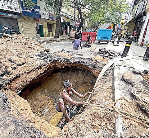சென்னை ஸ்ரீராமகிருஷ்ணா மடம் சாலையில் நேற்று ஏற்பட்ட ராட்சத பள்ளத்தை சீரமைக்கும் பணியில் ஈடுபட்ட ஊழியர். படம்: பு.க.பிரவீன்