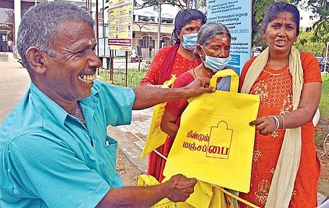 தூத்துக்குடி மாவட்ட ஆட்சியர் அலுவலக வளாகத்தில் பொதுமக்களுக்கு இலவசமாக மஞ்சள் பைகளை விநியோகம் செய்த மாற்றுத்திறனாளி முருகானந்தம். படம்: என்.ராஜேஷ்