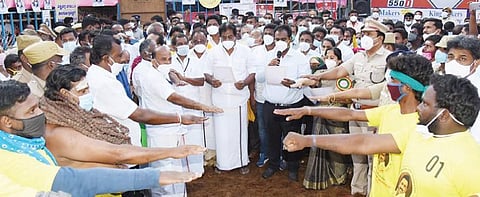 அலங்காநல்லூர் ஜல்லிக்கட்டு தொடங்கும் முன்பு அமைச்சர் பி.மூர்த்தி தலைமையில் உறுதிமொழி ஏற்ற மாடு பிடி வீரர்கள் உள்ளிட்டோர்.படம்: எஸ்.கிருஷ்ணமூர்த்தி