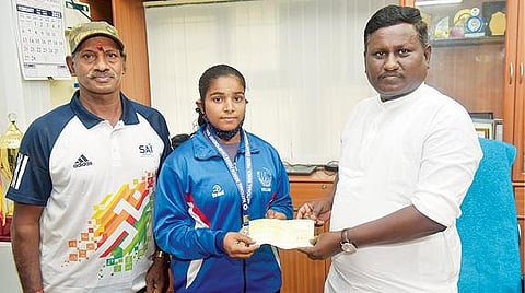 ரூ.50 ஆயிரத்துக்கான காசோலையை வலு தூக்கும் வீராங்கனை கவிதாவிடம் வழங்கிய சிருஷ்டி பள்ளிகள் குழுமத்தலைவர் எம்.எஸ்.சரவணன். படம்: வி.எம்.மணிநாதன்.