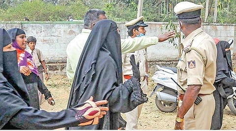 கர்நாடக மாநிலம் சிக்மகளூரு அருகே உள்ள ஒரு அரசு பள்ளி வளாகத்தில் முஸ்லிம் மாணவிகளிடம் ஹிஜாபை அகற்றுமாறு பள்ளி நிர்வாகத்தினரும் போலீஸாரும் வலியுறுத்தினர். படம்: பிடிஐ