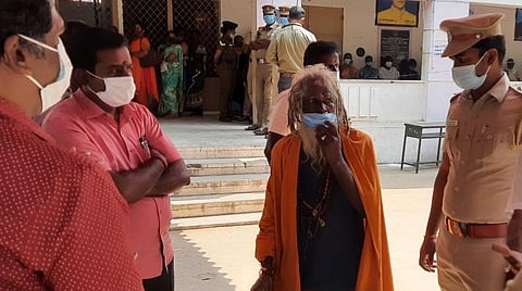 திருவண்ணாமலை 25-வது வார்டு மறு வாக்குப்பதிவில் தனது வாக்கை மற்றொருவர் செலுத்திவிட்டதாக கூறி தேர்தல் நடத்தும் அலுவலர் பார்த்தசாரதி, காவல் துணை கண்காணிப்பாளர் ராஜகாளியப்பனிடம் முறையிட்ட ‘சாது’ கோவிந்தராஜ். படம் – இரா.தினேஷ்குமார்.