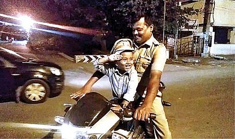 போலீஸ் தொப்பி அணிந்து எஸ்.ஐ., ராஜாவுடன் வலம் வந்த சிறுவன்.