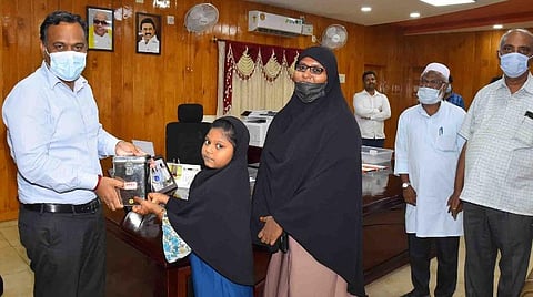 உண்டியலில் சேர்த்து வைத்த பணத்தை இலங்கை நிவாரண நிதிக்காக ராமநாதபுரம் ஆட்சியரிடம் வழங்கும் கீழக்கரை பள்ளி மாணவி பில்ஸா சாரா.