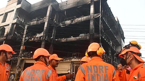 டெல்லியின் முன்ட்கா மெட்ரோ ரயில் நிலையம் அருகே அமைந்துள்ள கட்டிடத்தில் நேற்று முன்தினம் ஏற்பட்ட தீவிபத்தில் 30 பேர் உயிரிழந்தனர். தீ முற்றிலும் அணைந்த நிலையில் அங்கு மீட்புப் பணிகளை தேசிய பேரிடர் மீட்புப்படையினர் நடத்தி வருகின்றனர். இந்நிலையில் தீவிபத்து ஏற்பட்ட கட்டிடத்தை நேற்று காலை பார்வையிட்ட பாதுகாப்பு அதிகாரிகள், பத்திரிகையாளர்கள். படம்: பிடிஐ