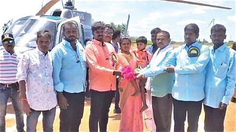 கோவில்பட்டி அருகே தெற்கு தீத்தாம்பட்டி கிராமத்தில் நடந்த கோயில் விழாவுக்கு ஹெலிகாப்டரில் வந்த நடராஜன் குடும்பத்துக்கு மலர்களை வழங்கி வரவேற்ற கிராம மக்கள்.