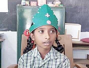 தலைமை ஆசிரியையின் இருக்கையில் கம்பீரமாக அமர்ந்திருக்கும் மாணவி சபிதா.