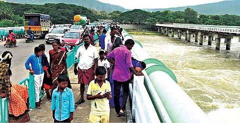 சேலம் மேட்டூர் அணை அருகே உள்ள எம்ஜிஆர் மேம்பாலத்தில் ஆபத்தை உணராமல் காவிரி ஆற்றில் செல்லும் வெள்ளத்தை வேடிக்கை பார்த்த மக்கள். படம்: எல்.பத்மநாபன்