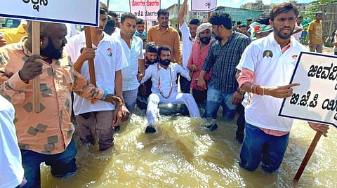வெள்ள பாதிப்புகளை சீர் செய்யாத கர்நாடகா அரசை கண்டித்து அம்மாநில இளைஞர் காங்கிரஸ் கமிட்டி தலைவர் டியூபில் மிதந்து போராட்டம் நடத்தினார்.
