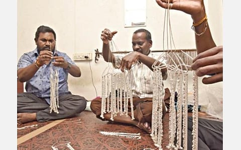 சேலம் செவ்வாய்பேட்டையில், முழு வடிவம் பெற்ற வெள்ளிக்கொலுசுகளை மெருகேற்றுவதற்காக வெள்ளிப்பட்டறையில் பாலீஷ் போடுவதற்கு தயார்படுத்தும் தொழிலாளர்கள். படம்: எஸ்.குரு பிரசாத்