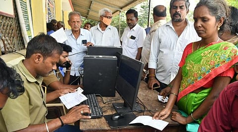 சிறப்பு முகாமில் மின் இணைப்புடன் ஆதார் எண் இணைக்க வரிசையில் காத்திருக்கும் மக்கள்.