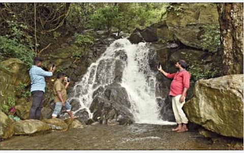 ஏற்காட்டில் பெய்த தொடர் மழையால் 6-வது கொண்டை ஊசி வளைவு அருகே ஏற்பட்டுள்ள திடீர் நீர் வீழ்ச்சியில் கொட்டும் தண்ணீரை புகைப்படம் எடுத்து மகிழ்ந்த இளைஞர்கள். படம்: எஸ்.குரு பிரசாத்