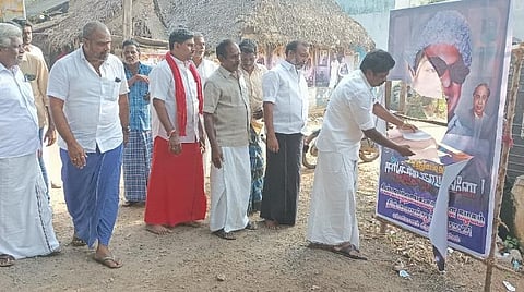 பேனர் கிழிந்திருப்பதை பார்க்கும் அதிமுகவினர்