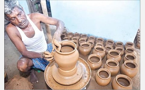 பொங்கல் பண்டிகை முன்னிட்டு விற்பனைக்காக வேலூர் சூளைமேடு பகுதியில் களிமண்ணாலான பானைகள் செய்யும் பணியில் மும்முரமாக ஈடுபட்டுள்ள தொழிலாளி. படம்: வி.எம்.மணிநாதன்.