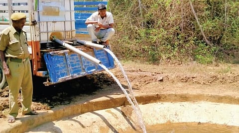 லாரி மூலம் கொண்டு வரப்பட்ட தண்ணீரை தேன்கனிக்கோட்டை வனப் பகுதியில் உள்ள குட்டையில் நிரப்பும் பணியில் ஈடுபட்டுள்ள வனத்துறை ஊழியர்கள்.
