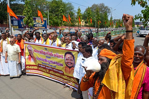 பல்வேறு கோரிக்கைகளை வலியுறுத்தி சேலம் ஆட்சியர் அலுவலகம் முன்பு கிராமக் கோயில் பூசாரிகள் பேரவையினர் சங்கு ஊதிக்கொண்டு நூதன ஆர்ப்பாட்டத்தில் ஈடுபட்டனர். | படம்: எஸ்.குரு பிரசாத்