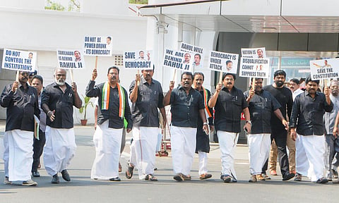 ராகுல் காந்தி மீதான பதவி இழப்பு நடவடிக்கையை கண்டித்து, சட்டப்பேரவை வளாகத்தில் நேற்று கருப்பு சட்டை அணிந்து, பதாகைகளுடன் போராட்டத்தில் ஈடுபட்ட காங்கிரஸ் எம்எல்ஏக்கள்.படம்: ம.பிரபு