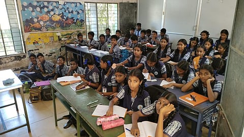 காரைக்குடி ராமநாதன் செட்டியார் நகராட்சி உயர்நிலைப் பள்ளியில் இடநெருக்கடியில் அமர்ந்துள்ள மாணவர்கள்.