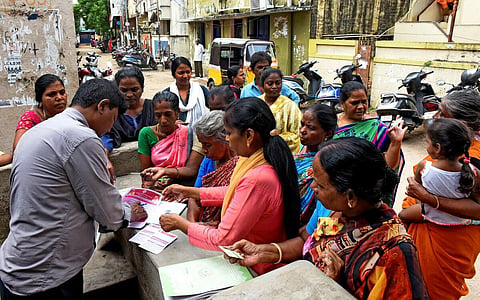 மகளிர் உரிமைத் தொகை ரூ.1,000 வழங்குவதற்கான விண்ணப்பம், டோக்கன் வீடு வீடாக விநியோகம் . சென்னை வில்லிவாக்கம் பஜனை கோவில் தெருவில் வீடுகளுக்கே சென்று டோக்கன் வழங்கிய நியாய விலைகடை ஊழியர் மற்றும் அருகே உள்ள நியாய விலைகடையில் தேதிவாரியாக வழங்கபடும் இடங்களை பற்றி அறிவிப்பு பலகை படங்கள்: ம.பிரபு
