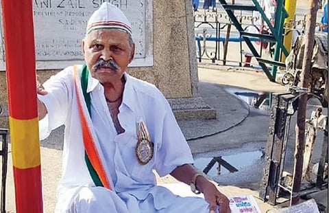 மணப்பாறையில் நேற்று காமராஜர் சிலை முன்பு கோரிக்கை அட்டைகளுடன் தர்ணாவில் ஈடுபட்ட சுதந்திர போராட்ட தியாகி சுந்தரம்.