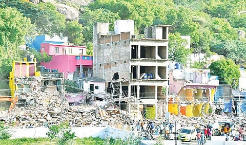 வேலூர் ஆட்சியர் அலுவலகம் எதிரே நெடுஞ்சாலை துறைக்கு சொந்தமான இடத்தில் ஆக்கிரமித்து கட்டப்பட்டிருந்த வீடுகளை ‘பொக்லைன்' இயந்திரங்கள் மூலம் நேற்று அகற்றப்பட்டது. படம்: வி.எம்.மணிநாதன்.