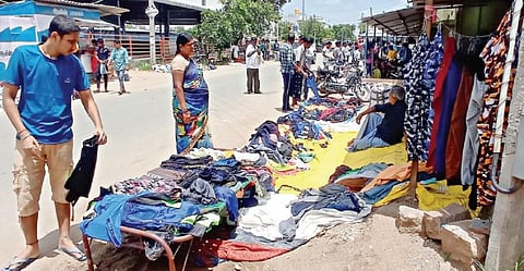 பர்கூர் அருகே அச்சமங்கலம் கூட்டுரோட்டில் அமாவாசையில் கூடும் ஜவுளிச் சந்தையில் ஆடையை தேர்வு செய்யும் பொதுமக்கள்.