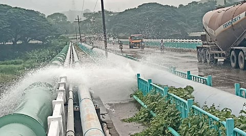 மேட்டூர் அனல்மின் நிலையம் எதிரேயுள்ள பாலத்தின் வழியாக செல்லும் குழாயில் உடைப்பு ஏற்பட்டு வெளியேறிய தண்ணீர்.