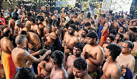 கார்த்திகை மாத முதல் நாளான நேற்று சென்னை மகாலிங்கபுரம் ஐயப்பன் கோயிலில், குருசாமியிடம் மாலை அணிந்துகொண்ட பக்தர்கள். படம்: ம.பிரபு