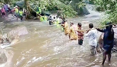 சதுரகிரி சுந்தரமகாலிங்கம் கோயில் பகுதியில் உள்ள ஓடையில் கயிறு கட்டி மீட்கப்பட்ட பக்தர்கள்.