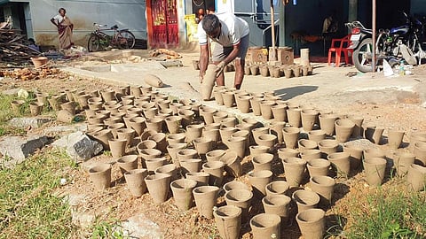 வேப்பனப்பள்ளி அருகே சீலப்பள்ளி கிராமத்தில் மண் தொட்டிகளை தயாரித்து வெயிலில் உலர வைக்கும் தொழிலாளி.