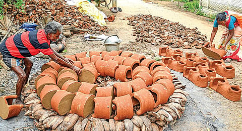 தஞ்சாவூர் அருகே புன்னைநல்லூர் மாரியம்மன் கோவில் பகுதியில் பொங்கல் பண்டிகைக்காக சூளையில் சுடுவதற்காக வரிசையாக மண் அடுப்புகளை அடுக்கும் பணியில் ஈடுபட்டுள்ளோர். | படம்: ஆர்.வெங்கடேஷ் |
