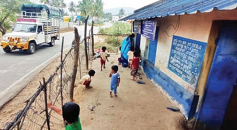 அஞ்செட்டி அருகே கேரட்டி கிராமத்தில் சாலையோரம் தடுப்புச் சுவர் இல்லாத அங்கன்வாடி மையத்தின் முன்பு விளையாடும் குழந்தைகள்.