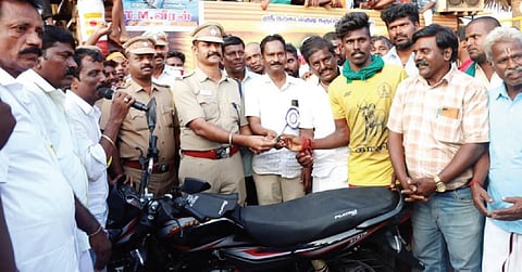 பெரிய சூரியூரில் நேற்று நடைபெற்ற ஜல்லிக்கட்டில் அதிக காளைகளை அடக்கிய நாமக்கல் மாவட்டத்தைச் சேர்ந்த மாடுபிடி வீரர் கார்த்திக்குக்கு மோட்டார் சைக்கிள் பரிசு வழங்கிய டிஎஸ்பி அறிவழகன்.