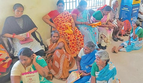 திட்டக்குடியில் உள்ள பொதுத்துறை வங்கி ஒன்றில் வைப்பு நிதி செலுத்திய வாடிக்கையாளர்கள் போதிய இருக்கை வசதியின்றி தரையில் அமர்ந்திருக்கின்றனர்.