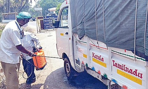 கோவை வேலந்தாவளம் சோதனைச்சாவடியில் கேரளாவில் இருந்து வரும் வாகனங்களுக்கு கிருமிநாசினி தெளிக்கும் பணியில் ஈடுபட்டுள்ள கால்நடைப் பராமரிப்புத் துறையினர்.