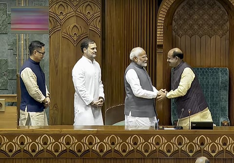 மக்களவை தலைவராக தேர்வு செய்யப்பட்ட ஓம் பிர்லாவுக்கு கைகுலுக்கி வாழ்த்து தெரிவித்த பிரதமர் மோடி, அவரை அழைத்துச் சென்று இருக்கையில் அமரவைத்தார். உடன் மக்களவை எதிர்க்கட்சி தலைவர் ராகுல் காந்தி, நாடாளுமன்ற விவகாரத் துறை அமைச்சர் கிரண் ரிஜிஜு.படம்: பிடிஐ