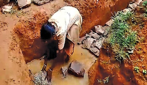 கூமாட்டி பழங்குடியின கிராமத்தில் புதிதாக கட்டப்படும் வீடுகளுக்கு, சிமென்ட் கலவைக்கு பதிலாக செம்மண்ணில் அமைக்கப்பட்டு வரும் அஸ்திவாரம்.