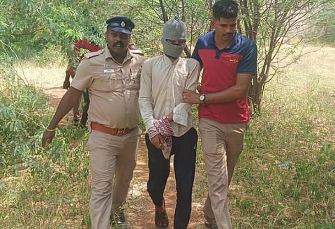 இளைஞரை கொன்று புதைத்த இடத்தை காட்டுவதற்காக கைதானவரை அழைத்துச் செல்லும் போலீஸார்.