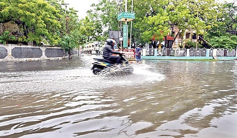 தொடர் மழையால் தூத்துக்குடி பழைய மாநகராட்சி அலுவலகம் அருகே குளம்போல தேங்கிய மழைநீரில் சிரமப்பட்டு செல்லும் இருசக்கர வாகனம்.