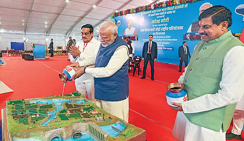 மத்திய பிரதேச மாநிலம் கஜுராஹோவில் கென் - பெட்வா ஆறுகள் இணைப்பு திட்டத்துக்கு பிரதமர் மோடி நேற்று அடிக்கல் நாட்டினார். இரு ஆறுகளில் இருந்து எடுத்து வரப்பட்ட தண்ணீரை இணைப்பு திட்டத்தின் மாதிரி வடிவம் மீது ஊற்றினார். உடன், மாநில முதல்வர் மோகன் யாதவ், மத்திய அமைச்சர் சி.ஆர்.பாட்டீல். படம்: பிடிஐ