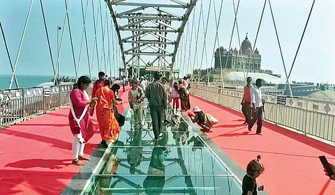 கன்னியாகுமரியில் கடல் நடுவே உள்ள கண்ணாடி இழை பாலத்தில் காலணி இன்றி நடந்து செல்லும் சுற்றுலா பயணிகள்.