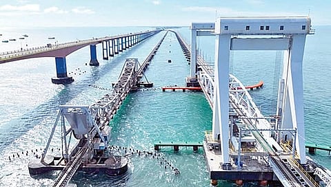 பாம்பன் பழைய ரயில் பாலத்துக்கு அருகே திறப்பு விழாவுக்குத் தயாராக உள்ள புதிய ரயில் தூக்குப் பாலம்.