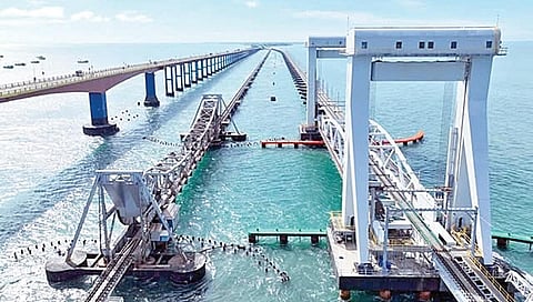 பாம்பன் பழைய ரயில் பாலத்துக்கு அருகே திறப்பு விழாவுக்குத் தயாராக உள்ள புதிய ரயில் தூக்குப் பாலம்.
