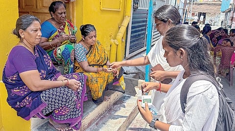 உறையூர் மின்னப்பன் தெருவில் வீடு வீடாகச் சென்று மாத்திரைகள் வழங்கும் சுகாதார பணியாளர்கள். | படம்: ர.செல்வமுத்துகுமார் |